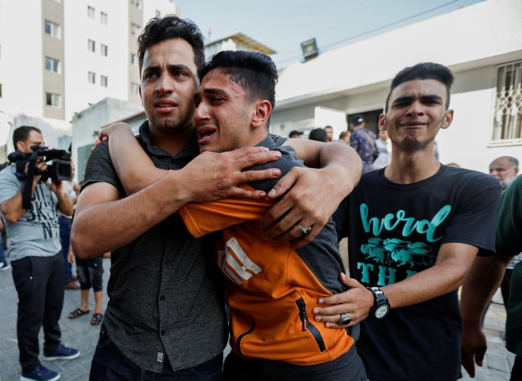 Palestinians react at a hospital following Israeli strikes in Gaza City August 5, 2022. REUTERS/Ibraheem Abu Mustafa