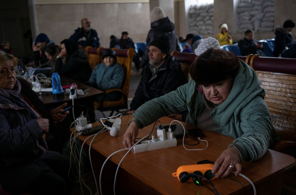 People charge their electronic devices at a railway station after Russia's military retreat from Kherson, Ukraine November 29, 2022. REUTERS/Anna Voitenko