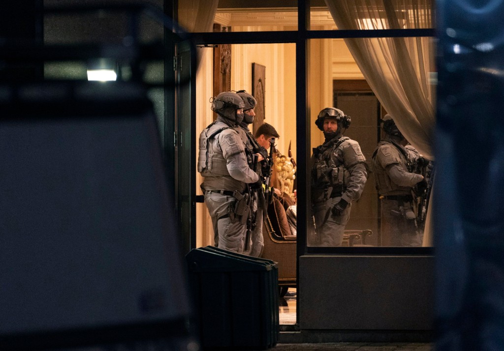 York Regional Police tactical officers stand in the lobby of a condominium building in Vaughan, Ontario, Sunday, Dec. 18, 2022. Police said multiple people are dead, including the suspect, after a shooting in a unit of the building. (Arlyn McAdorey/The Canadian Press via AP)