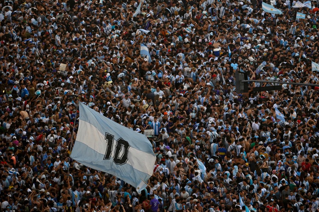 Fans hold up a flag marked with Lionel Messi's shirt number 10 in Buenos Aires