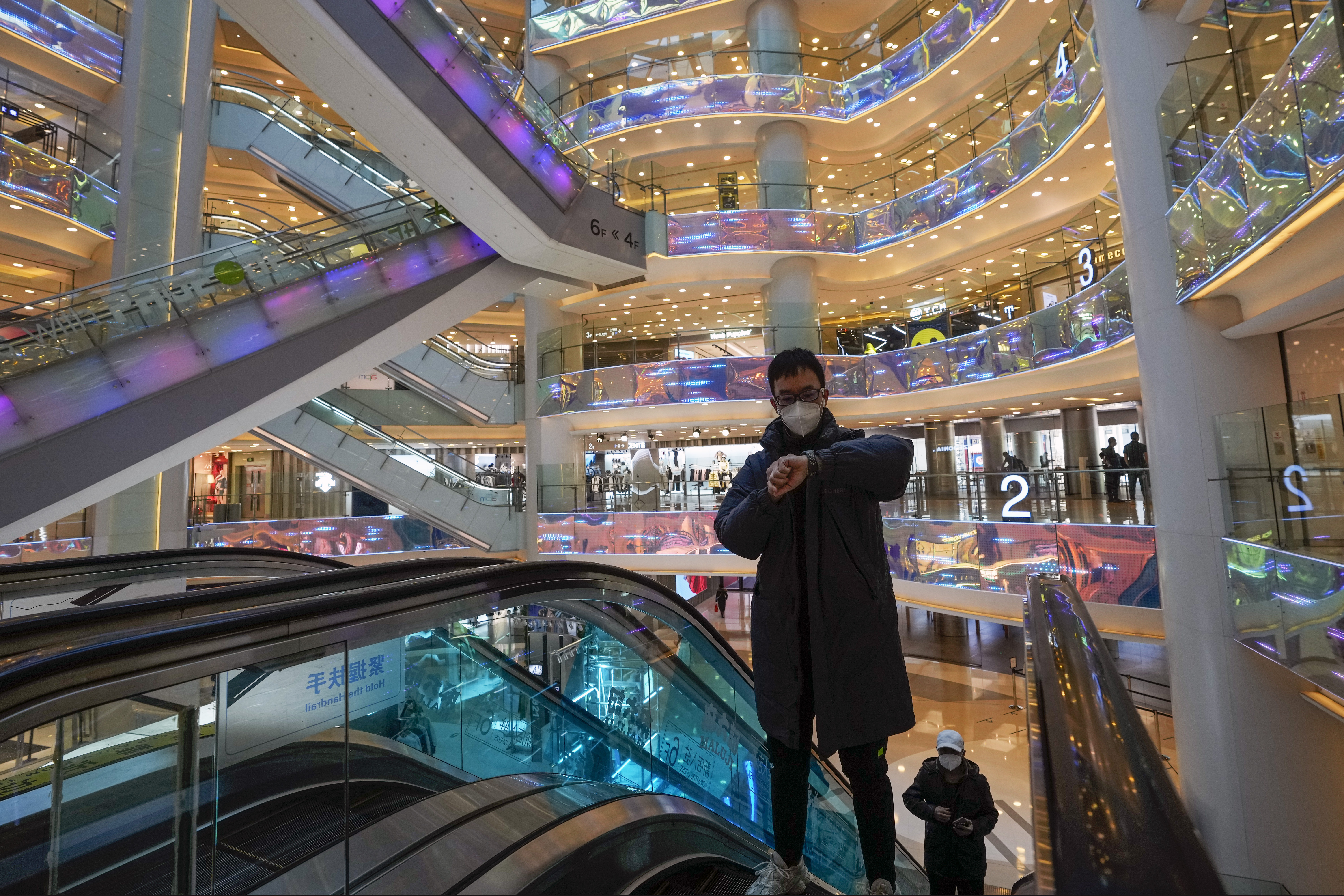 A shoppers rides on an escalator at a reopened shopping mall after in China