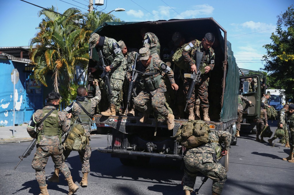 Troops get off a truck in the suburb of Soyapango, after El Salvador's President Nayib Bukele announced the deployment of 10,000 security forces to the troubled area which for years has been considered a stronghold of the violent Mara Salvatrucha and Barrio 18 gangs, in San Salvador, El Salvador December 3, 2022. REUTERS/Jose Cabezas