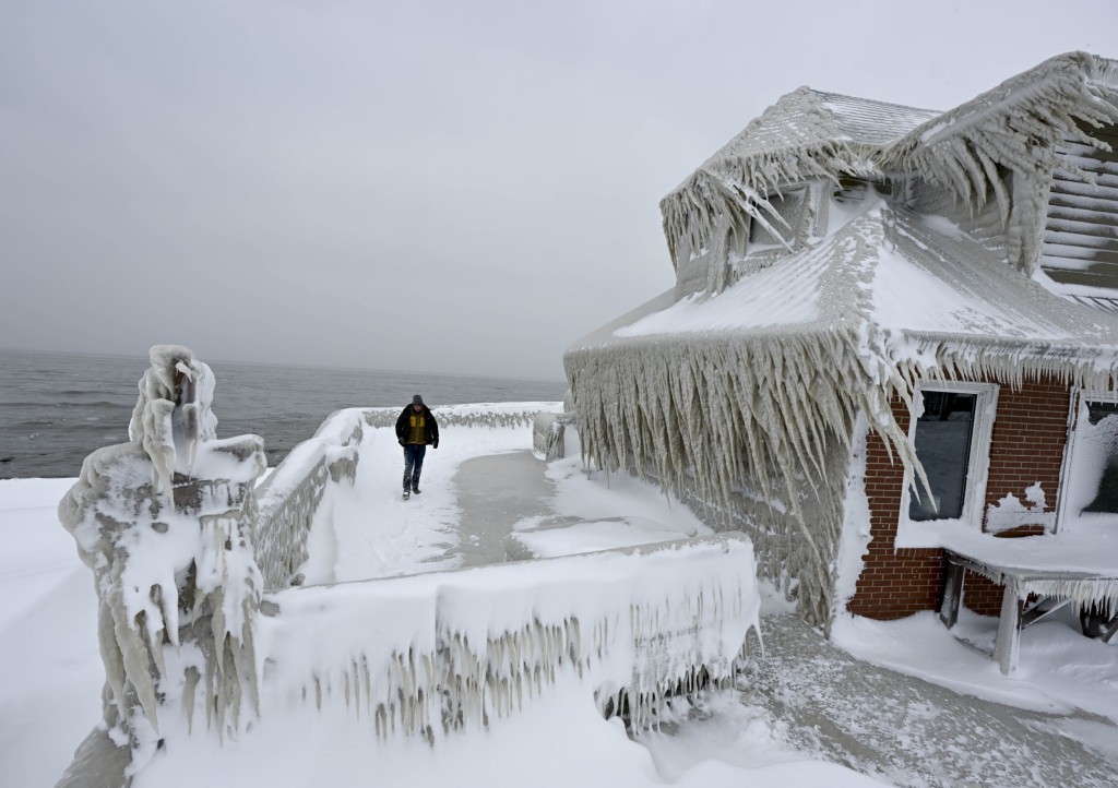 NEW YORK, UNITED STATES - DECEMBER 26: A man near a house completely covered in ice after snowfall as death toll in the snowstorm, which was effective, reached 26 in Buffalo, New York, United States on December 26, 2022. (Photo by Fatih Aktas/Anadolu Agency via Getty Images)