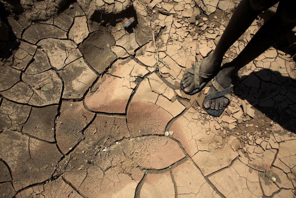 A young boy from the remote Turkana tribe in Northern Kenya stands on a dried up river bed