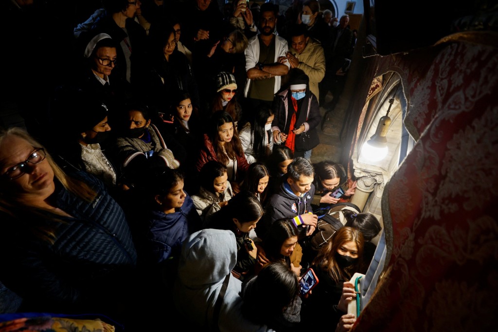 People gather at the Church of Nativity, ahead of Latin Patriarch of Jerusalem Pierbattista Pizzaballa's arrival to attend Christmas celebrations in Bethlehem, in the Israeli-occupied West Bank December 24, 2022. REUTERS/Mussa Issa Qawasma