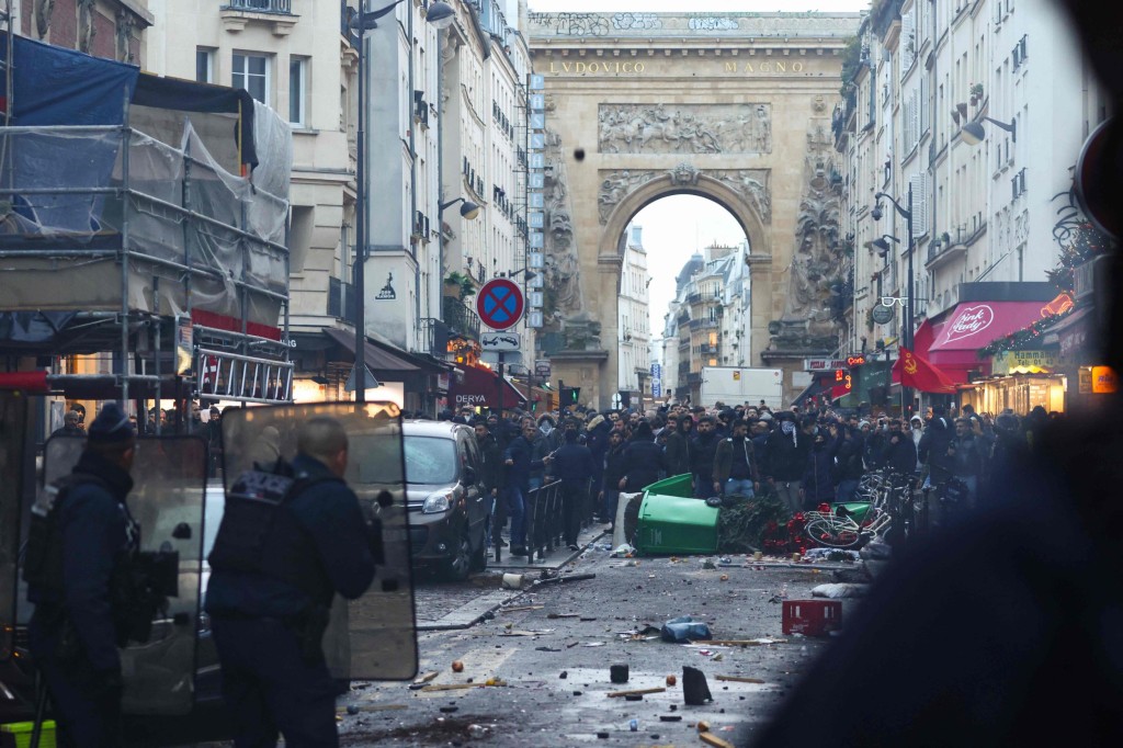 Protestors clashes with French riot police officers following a statement by French Interior Minister Gerald Darmanin (unseen) at the site where several shots were fired along rue d'Enghien in the 10th arrondissement, in Paris on December 23, 2022. - Two people were killed and four injured in a shooting in central Paris on December 23, 2022, police and prosecutors said, adding that the shooter, in his 60s, had been arrested. The motives of the gunman remain unclear, with two of the four injured left in a serious condition, the French officials said. (Photo by Thomas SAMSON / AFP) (Photo by THOMAS SAMSON/AFP via Getty Images)