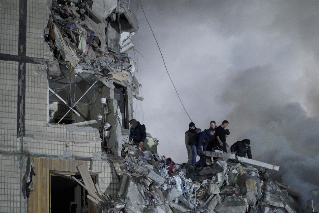 Rescuers works on a residential building destroyed after a missile strike, in Dnipro on January 14, 2023. - A strike on a residential building in the eastern Ukrainian city of Dnipro on January 14, 2023 killed at least five people and wounded 39, officials said, as the president blasted Russian