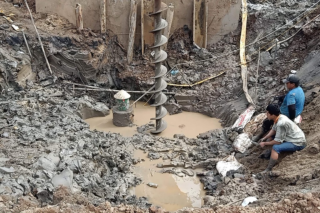 Rescuers gather at the site of where a 10-year-old boy is thought to be trapped in a 35-metre deep shaft at a bridge construction area in Vietnam's Dong Thap province on January 2, 2023. - Hundreds of rescuers in Vietnam battled January 2 to free a 10-year-old boy who fell into a 35-metre deep hole on a construction site two days ago. (Photo by AFP) (Photo by STR/AFP via Getty Images)