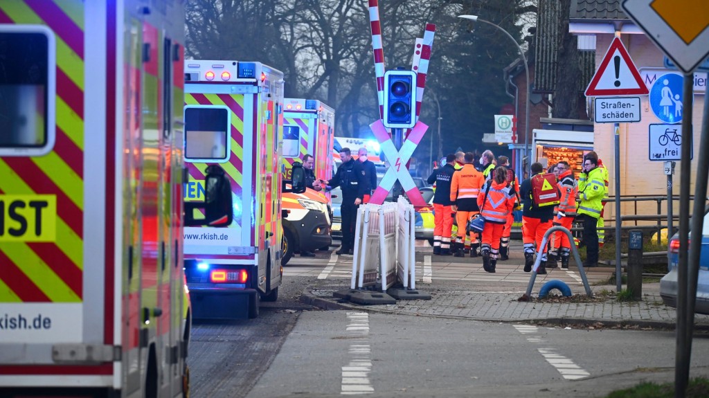 Police and rescue services are on duty at a level crossing near Brokstedt station in Brockstedt, Germany, Wednesday, Jan. 25, 2023. Several people were injured in a knife attack on a regional train from Kiel to Hamburg on Wednesday. A man had attacked passengers with a knife shortly before arriving at Brokstedt station. (Jonas Walzberg/dpa via AP)