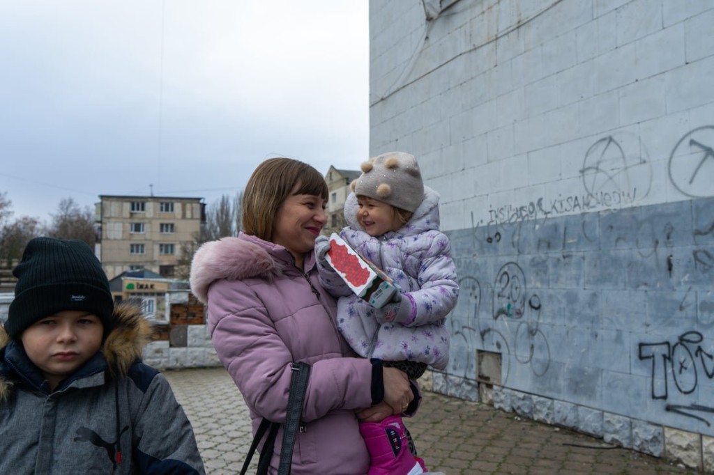 Snapshot - Ukraine 1 year on Yulia with her kids Anastasiia and Kyrylo have received winter kits from the IRC containing blankets and sleeping bags. The charity has equipped 500 homes with fuel stoves, provided materials for almost 4,500 homes requiring emergency repairs and supplied 1,400 individuals with warm clothes.