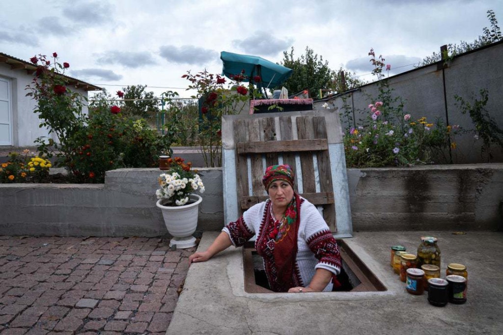 Snapshot - Ukraine 1 year on Caption: Olga takes out jars of pickled vegetables from her cellar. When the Russians occupied her neighbourhood, she and her neighbours spent entire days and nights in the small cellar, using it as a bomb shelter and surviving from her supplies of vegetables.