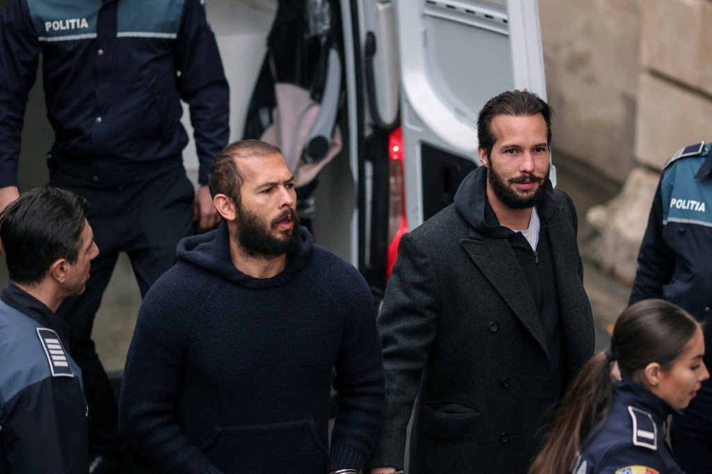 Andrew Tate and his brother Tristan are escorted by police officers inside the headquarters of the Bucharest Court of Appel, in Bucharest, Romania, February 27, 2023. Inquam Photos/Alexandru Busca via REUTERS ATTENTION EDITORS - THIS IMAGE WAS PROVIDED BY A THIRD PARTY. ROMANIA OUT. NO COMMERCIAL OR EDITORIAL SALES IN ROMANIA