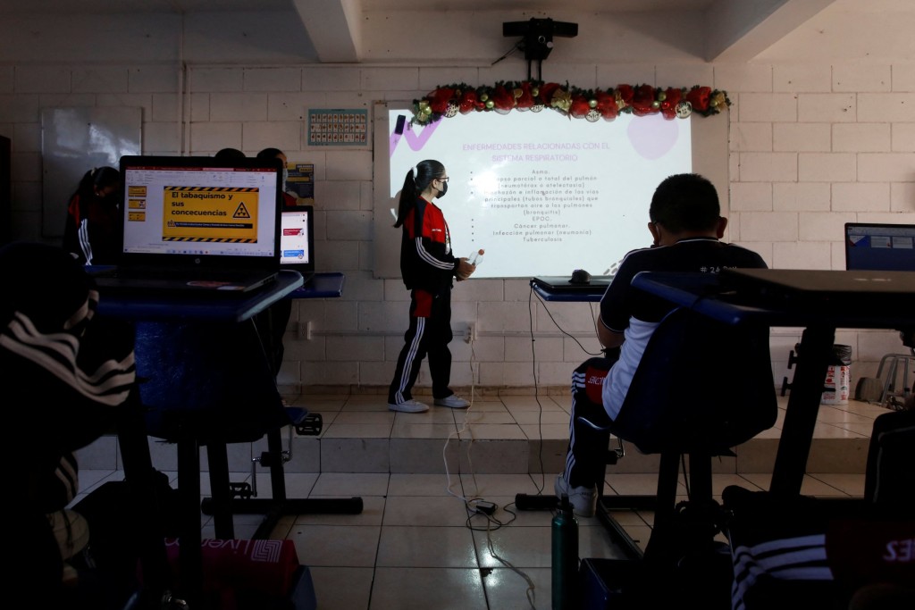 High school students are pictured in a classroom with bike desks, as part of a program to improve physical health and increase concentration during classes, in San Nicolas de los Garza, Mexico January 18, 2023. REUTERS/Daniel Becerril