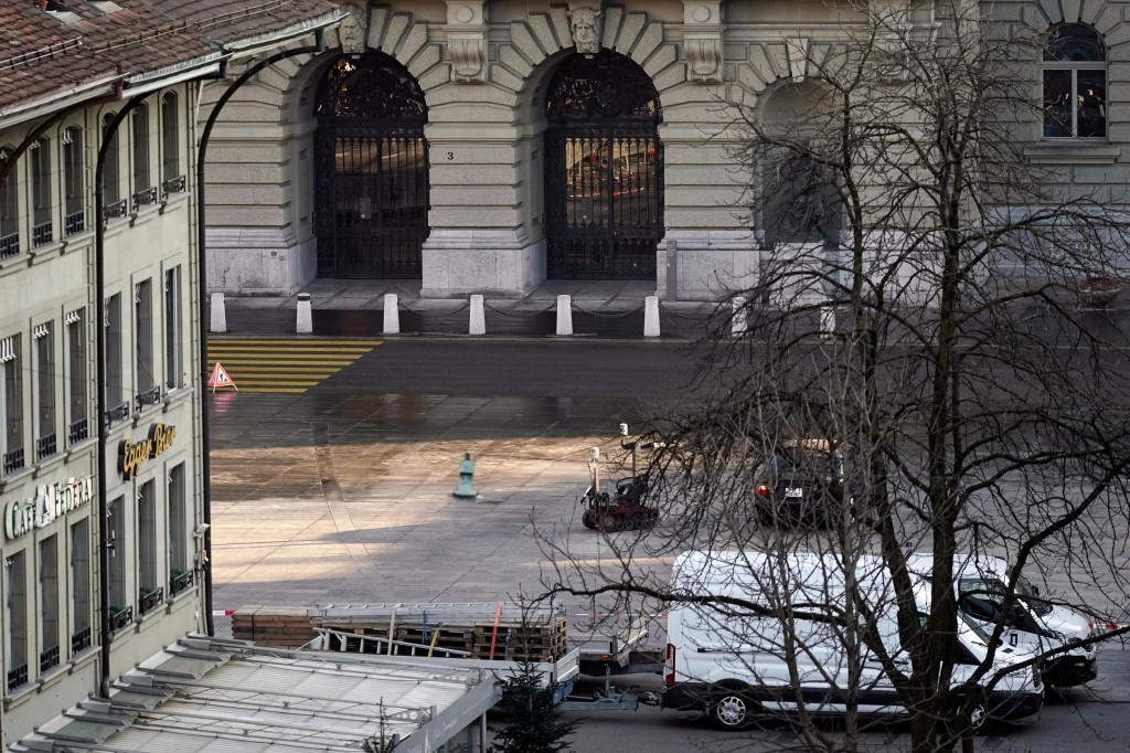 A police robot stands next to a suspicious car in front of the Swiss Parliament, the Bundeshaus in Bern, during the large-scale operation of the Bern police, where several buildings were evacuated and the Bundesplatz and some streets around were widely cordoned off, on Tuesday, Feb. 14, 2023. A man wearing a bulletproof vest and weapon holster, who allegedly parked the car in the middle of the Bundesplatz near one of its entrances, was found to explosives and arrested. (Manuel Lopez/Keystone via AP)