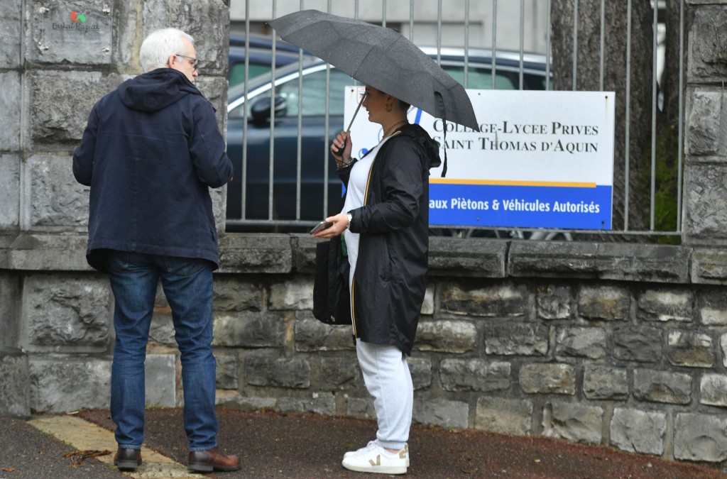 People stand at the entrance of the Saint-Thomas dAquin middle school in Saint-Jean-de-Luz, south-western France, where a teacher died after being stabbed by a student, on February 22, 2023 (Photo by GAIZKA IROZ / AFP) (Photo by GAIZKA IROZ/AFP via Getty Images)