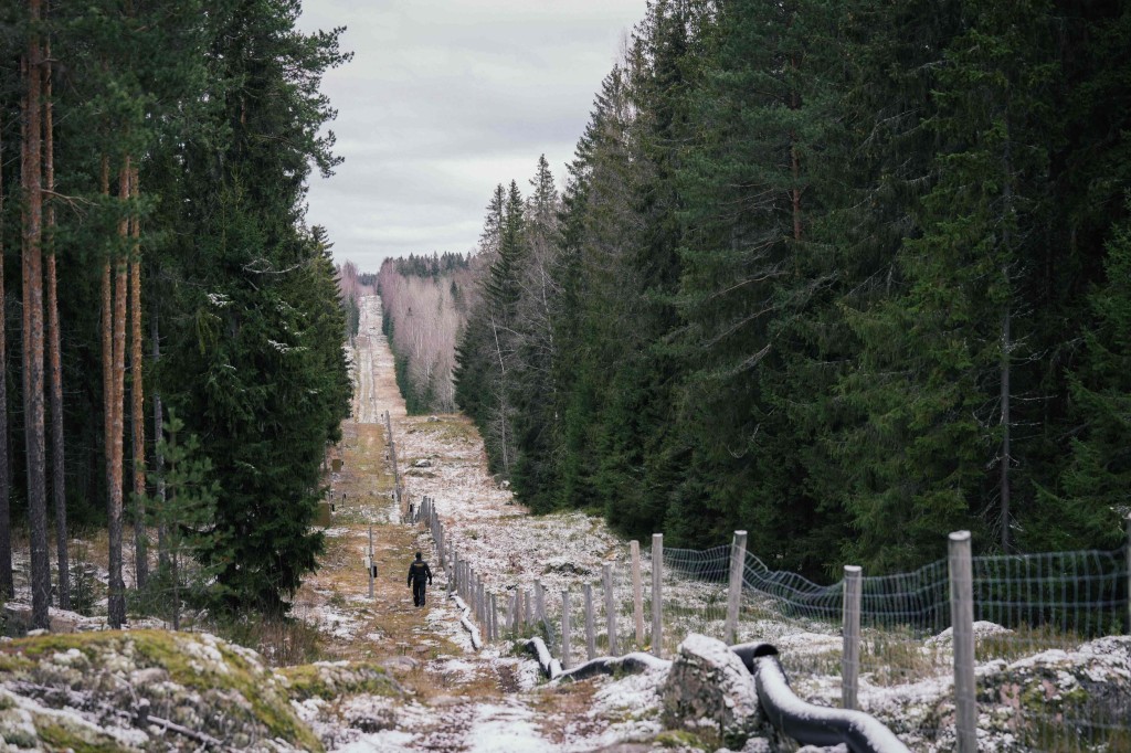 (FILES) In this file photo taken on November 18, 2022 Senior border guard officer Juho Pellinen walks along a fence marking the boundary area between Finland and the Russian Federation near the border crossing of Pelkola, in Imatra, Finland. - Finland has started building its 200-kilometre fence on the Russian border, starting with a three-kilometre pilot fence at the southeastern border crossing in Imatra, the border guard said on February 28, 2023. In total, Finland plans to fence 200 kilometres of its 1,300-kilometre border with Russia at a cost of around 380 million euros ($394 million). (Photo by Alessandro RAMPAZZO / AFP) (Photo by ALESSANDRO RAMPAZZO/AFP via Getty Images)