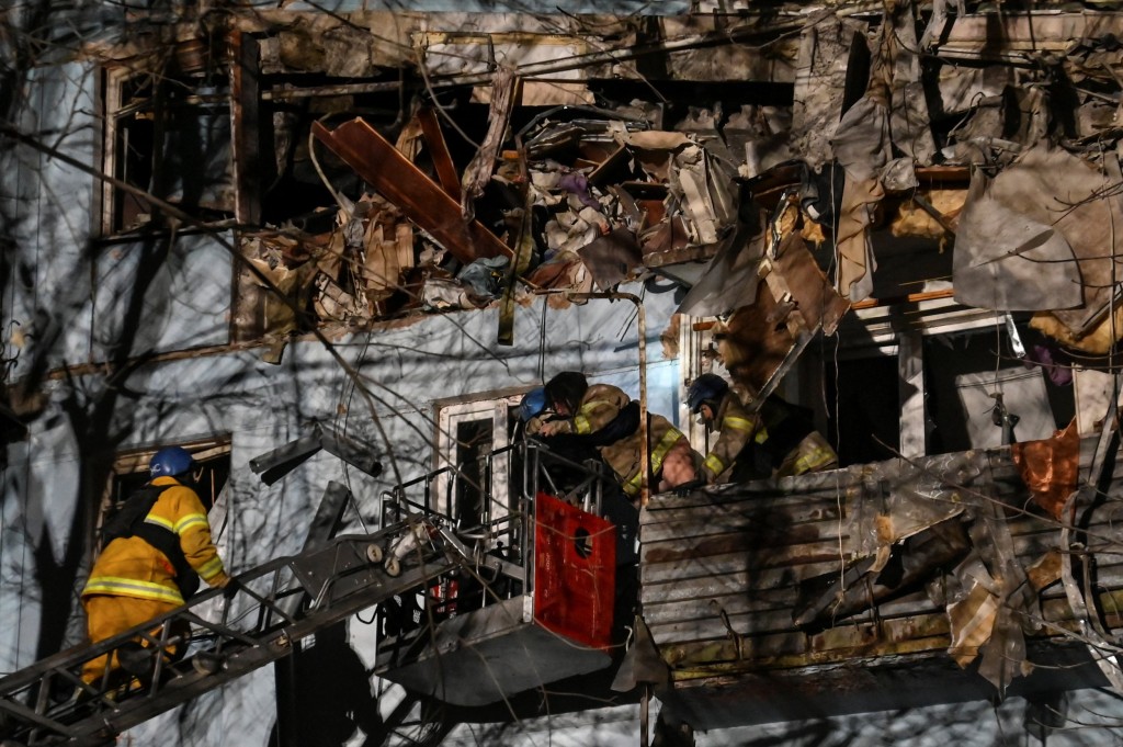 Rescuers evacuate a pregnant woman Anna, 27, from a residential building heavily damaged by a Russian missile strike, amid Russia's attack on Ukraine, in Zaporizhzhia, Ukraine March 2, 2023. REUTERS/Stringer